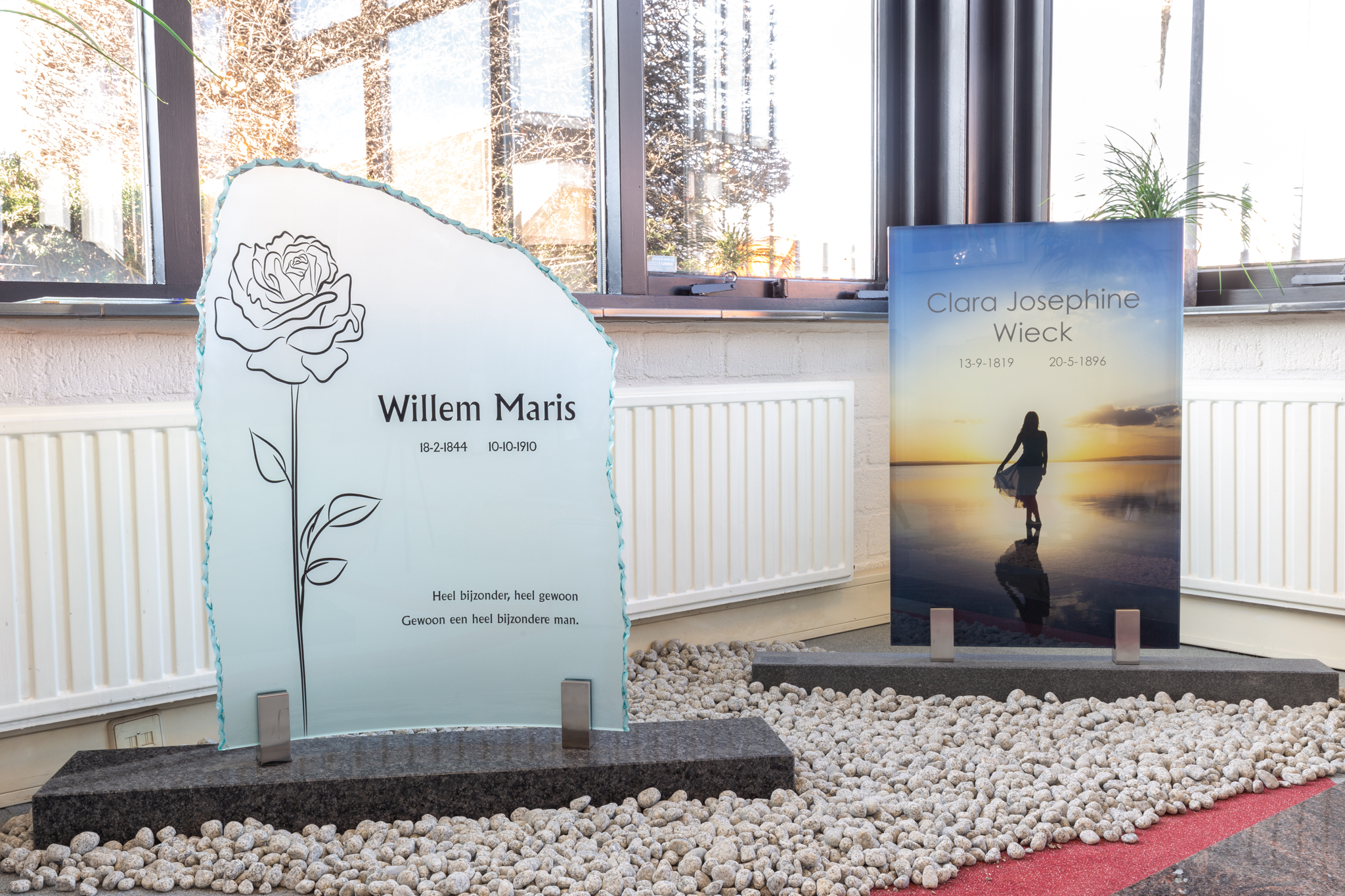 Staande glasgrafstenen in een showroom.